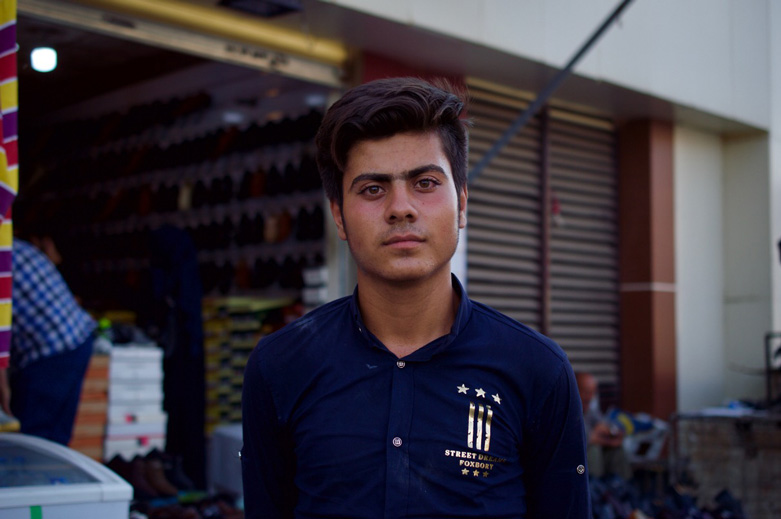 Young man working at a falafel shop.